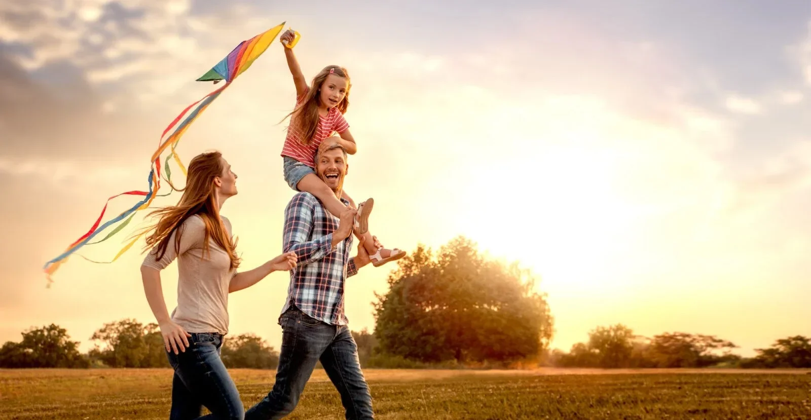 A family in a field with a kite.